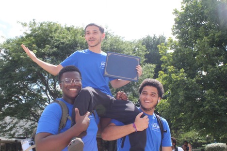 Two students holding another up on their shoulders.