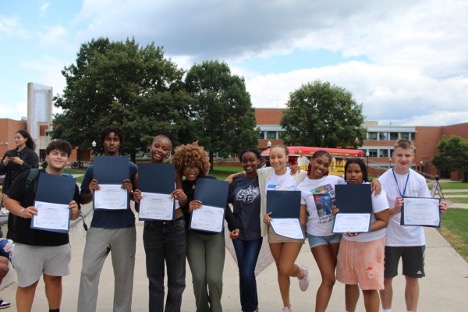 A group of students holding up their awards from the Summer Institute Program.