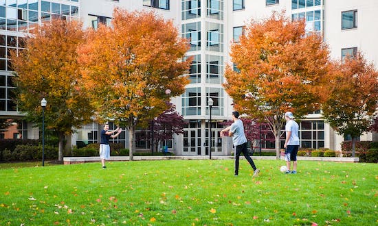 Students playing football in front of a residence hall